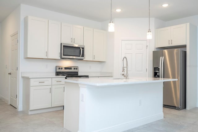 kitchen with hanging light fixtures, white cabinets, stainless steel appliances, and a center island with sink