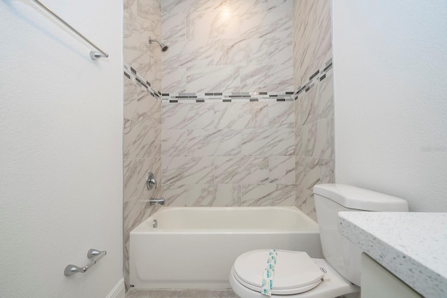 full bathroom featuring vanity, tiled shower / bath combo, and toilet