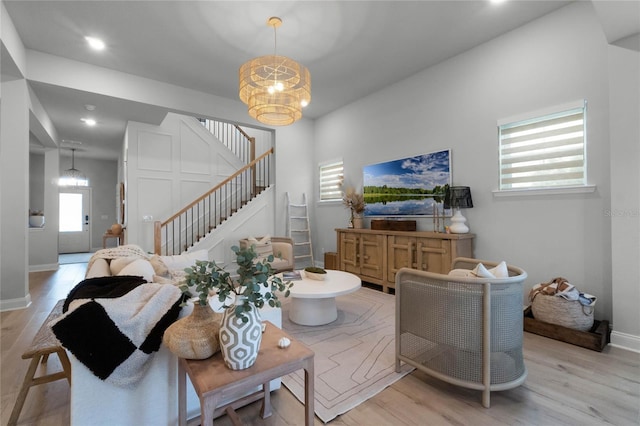 living room with light hardwood / wood-style flooring and a notable chandelier