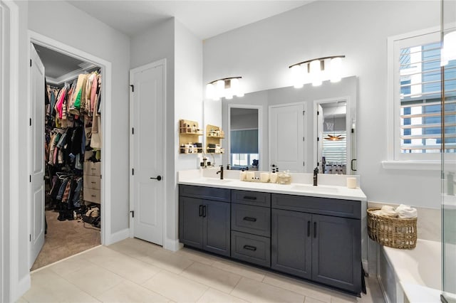 bathroom with tile patterned floors, vanity, ornamental molding, and a bath