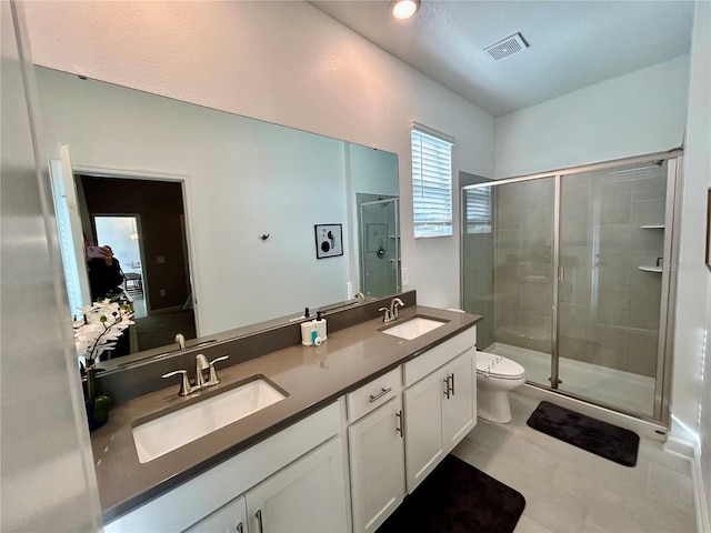 bathroom with vanity, a shower with shower door, and toilet