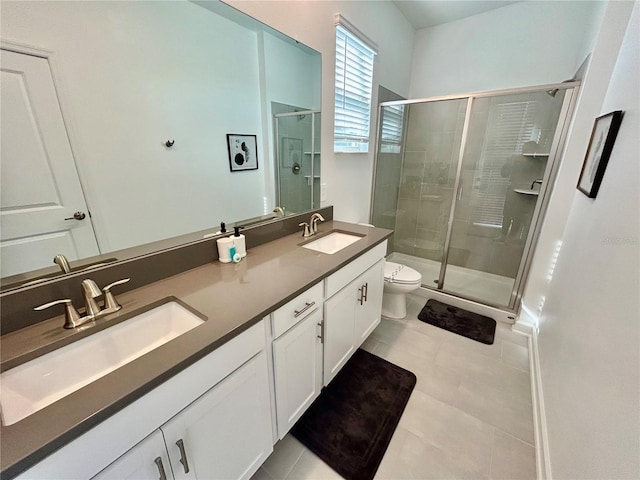 bathroom with tile patterned floors, vanity, toilet, and a shower with door