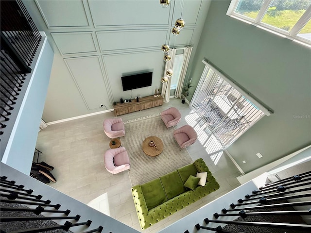 living room featuring light tile patterned flooring and a towering ceiling