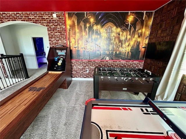 rec room with carpet and brick wall