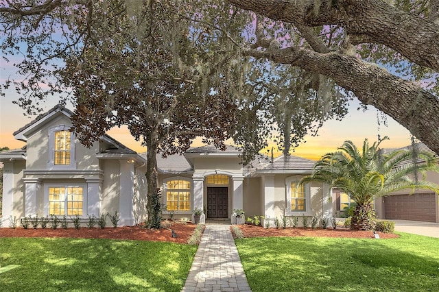 view of front of home with a lawn and a garage