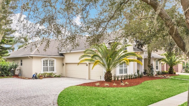 1610 Conway Isle Cir, Belle Isle, FL 32809 - view of front of house with a garage, decorative driveway, stucco siding, a tiled roof, and a front lawn