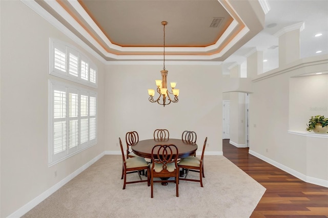 1610 Conway Isle Cir, Belle Isle, FL 32809 - dining area with a chandelier, a tray ceiling, a towering ceiling, ornamental molding, and wood finished floors