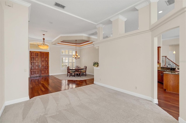 carpeted empty room with crown molding and a chandelier