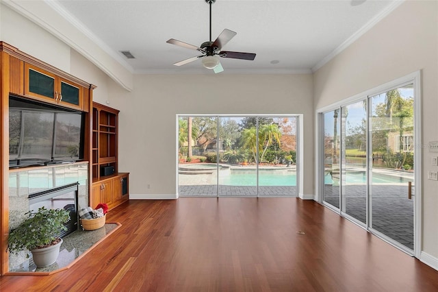 unfurnished living room featuring ceiling fan, dark hardwood / wood-style floors, and ornamental molding