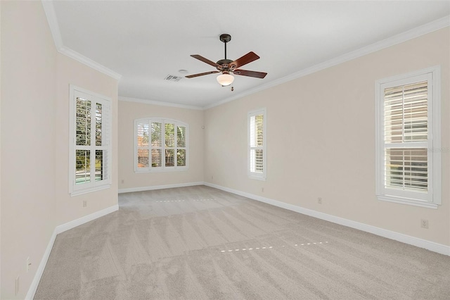 empty room featuring light colored carpet, plenty of natural light, ceiling fan, and crown molding