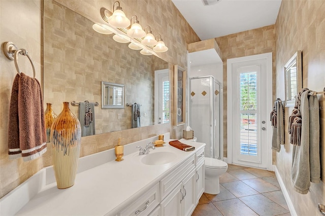 bathroom with tile patterned floors, vanity, toilet, and walk in shower