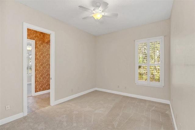 carpeted spare room with ceiling fan