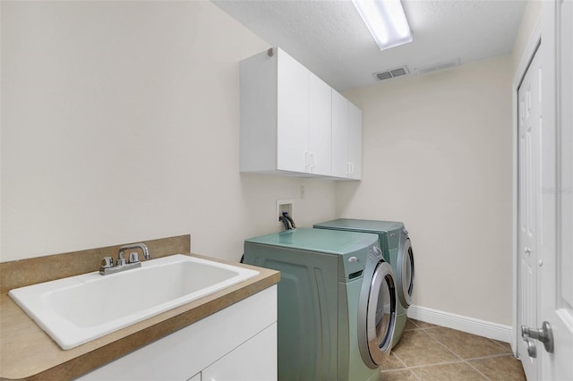 1610 Conway Isle Cir, Belle Isle, FL 32809 - laundry area with cabinet space, washing machine and clothes dryer, light tile patterned flooring, and a textured ceiling