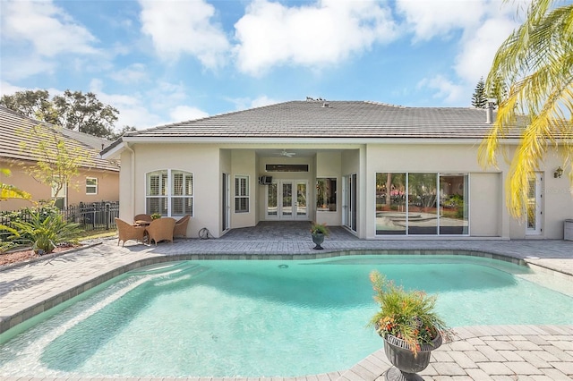 rear view of property with ceiling fan and a patio area