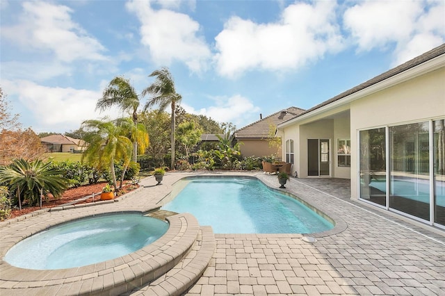 view of swimming pool featuring an in ground hot tub and a patio