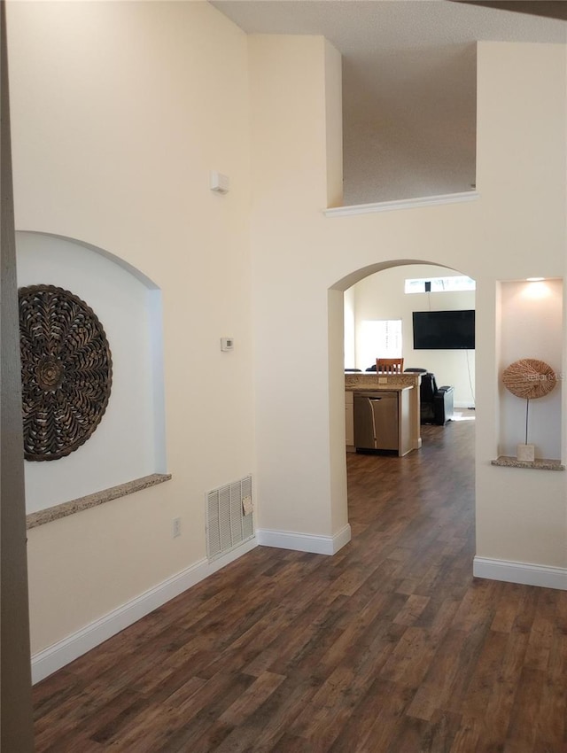 interior space featuring dark wood-type flooring and a high ceiling