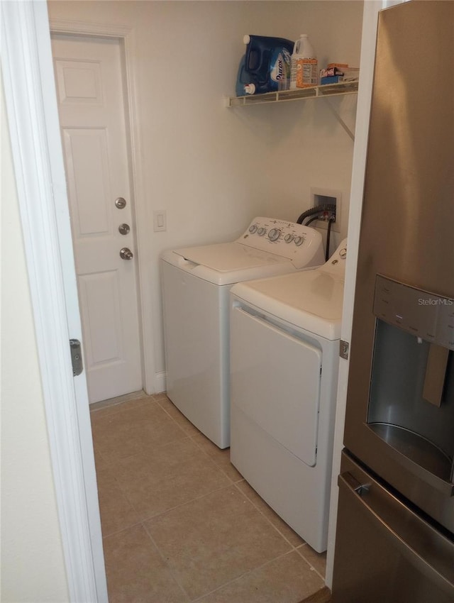 laundry area with separate washer and dryer and light tile patterned floors