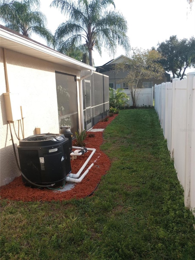 view of yard with a sunroom and central air condition unit