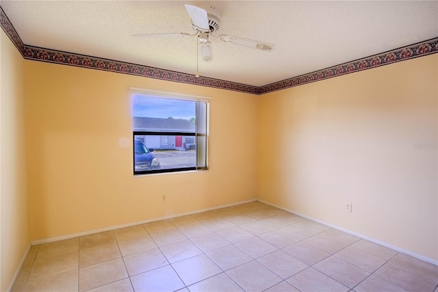 tiled spare room with ceiling fan and a textured ceiling