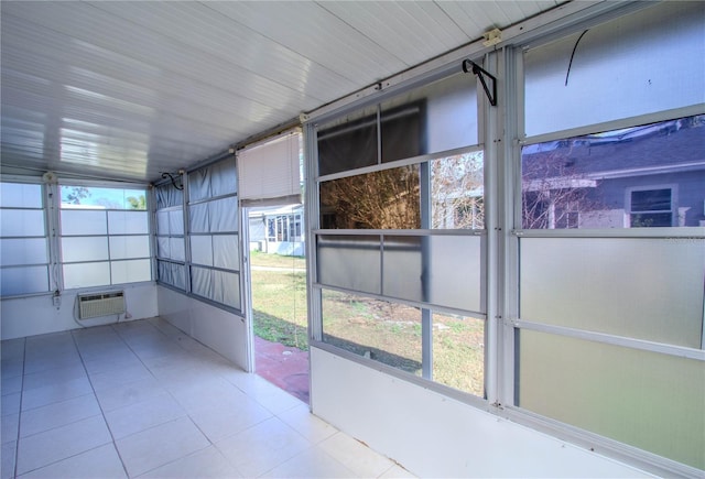 unfurnished sunroom featuring a wall unit AC and a wealth of natural light