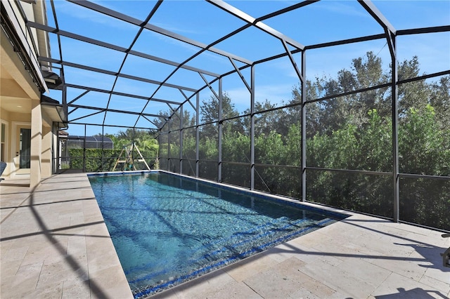 view of pool featuring glass enclosure and a patio