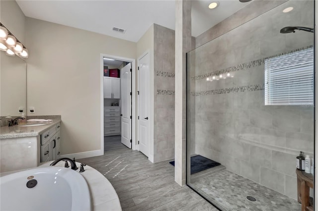 bathroom featuring hardwood / wood-style floors, vanity, and independent shower and bath