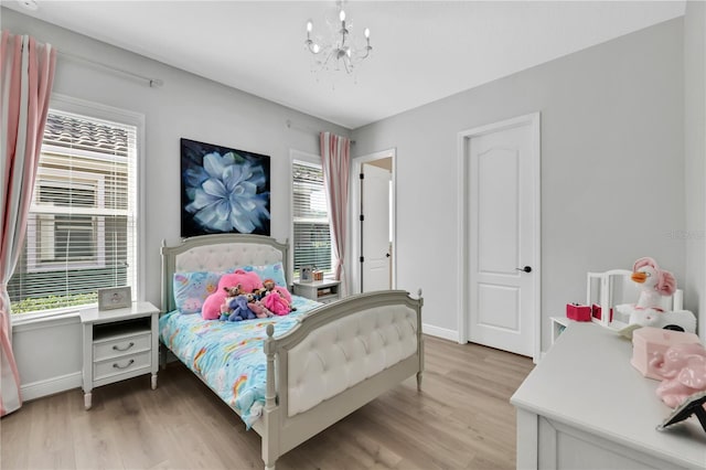 bedroom with an inviting chandelier and light hardwood / wood-style flooring