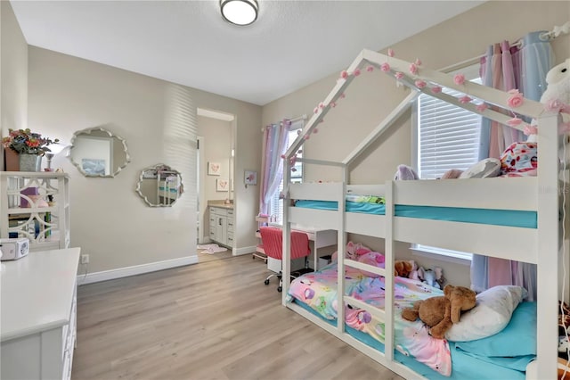 bedroom with wood-type flooring and ensuite bath