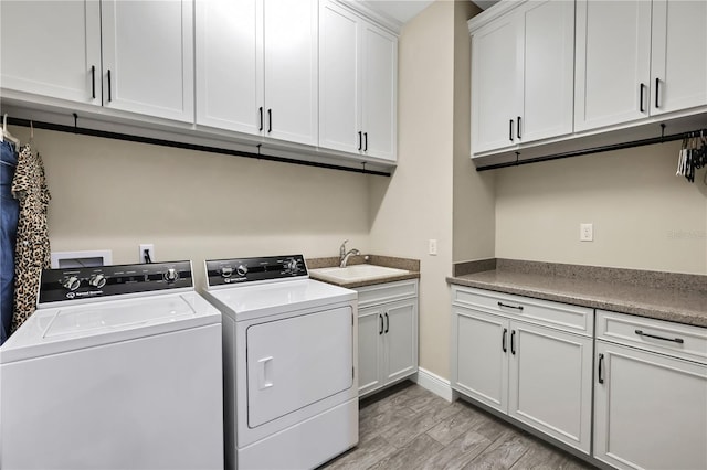 washroom with washer and dryer, cabinets, light wood-type flooring, and sink