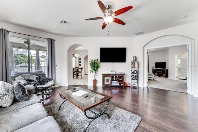 living room featuring ceiling fan and dark wood-type flooring