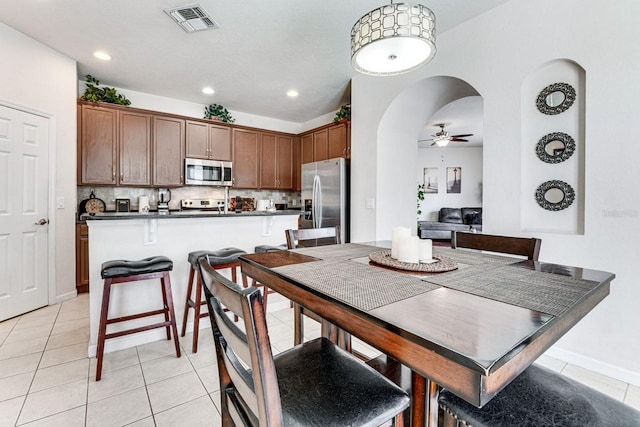 tiled dining area with ceiling fan