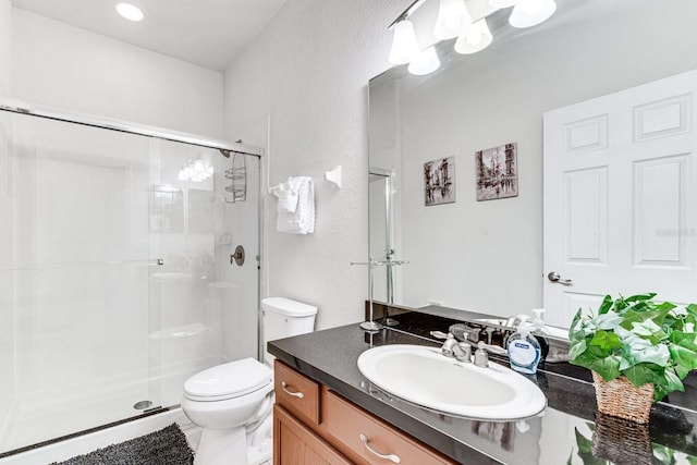 bathroom with vanity, an enclosed shower, and toilet