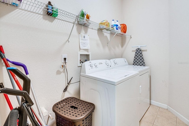 laundry room with washing machine and dryer and light tile patterned floors