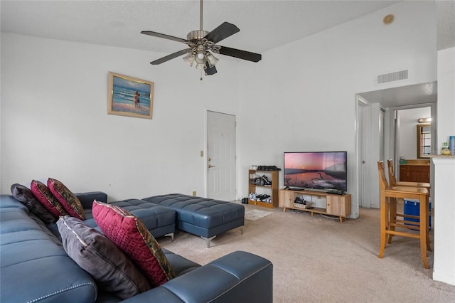 carpeted living room with a textured ceiling, ceiling fan, and lofted ceiling