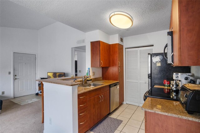 kitchen featuring dishwasher, sink, kitchen peninsula, a textured ceiling, and light tile patterned floors