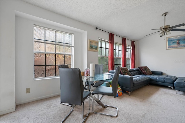 carpeted dining area with ceiling fan and a textured ceiling