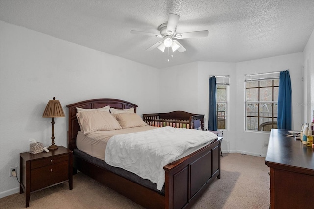 carpeted bedroom with a textured ceiling and ceiling fan