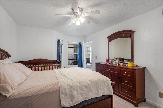 carpeted bedroom with ceiling fan and a textured ceiling