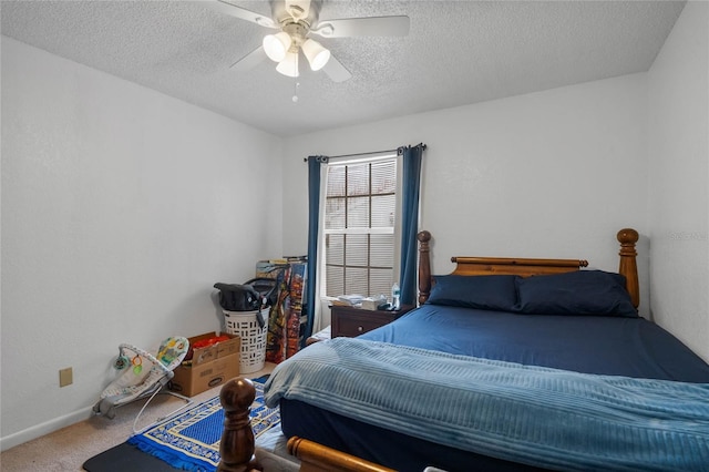 carpeted bedroom featuring ceiling fan and a textured ceiling