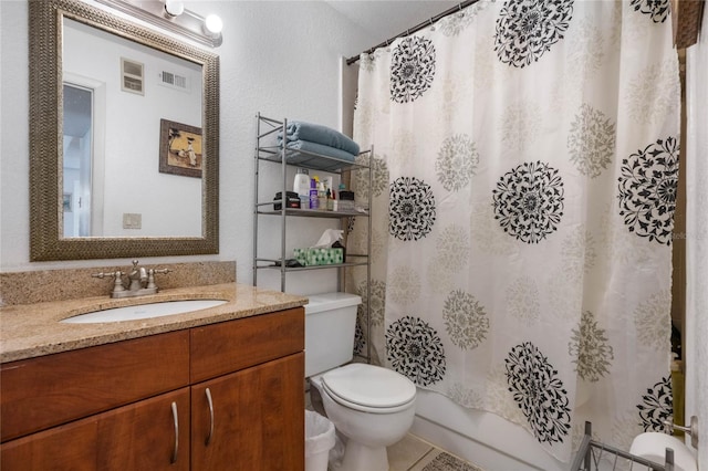 bathroom with tile patterned flooring, vanity, and toilet