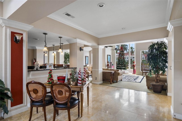 dining space featuring ornate columns, ceiling fan, and crown molding