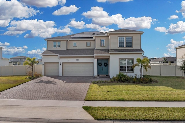 view of front of house featuring solar panels, a garage, and a front yard