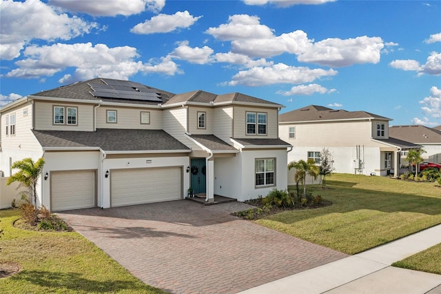 view of front of home featuring solar panels, a front lawn, and a garage