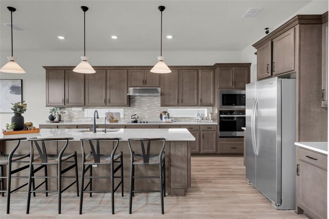 4360 Sunset Preserve Blvd, Orlando, FL 32820 - kitchen with a kitchen bar, appliances with stainless steel finishes, sink, decorative light fixtures, and a center island with sink