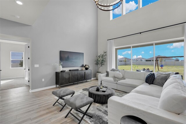 4360 Sunset Preserve Blvd, Orlando, FL 32820 - living room featuring light hardwood / wood-style floors, a high ceiling, and an inviting chandelier