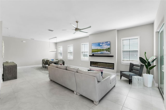 living room with light tile patterned floors, plenty of natural light, and ceiling fan