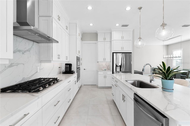 kitchen with white cabinets, sink, stainless steel appliances, and wall chimney range hood