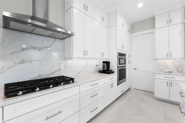 kitchen with white cabinets, wall chimney exhaust hood, decorative backsplash, and gas cooktop