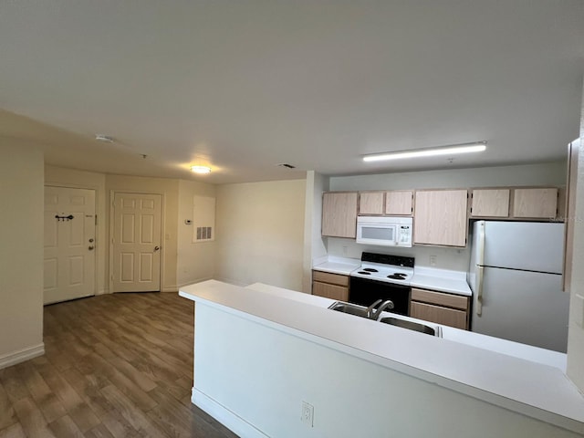 kitchen with dark hardwood / wood-style floors, white appliances, sink, and light brown cabinetry