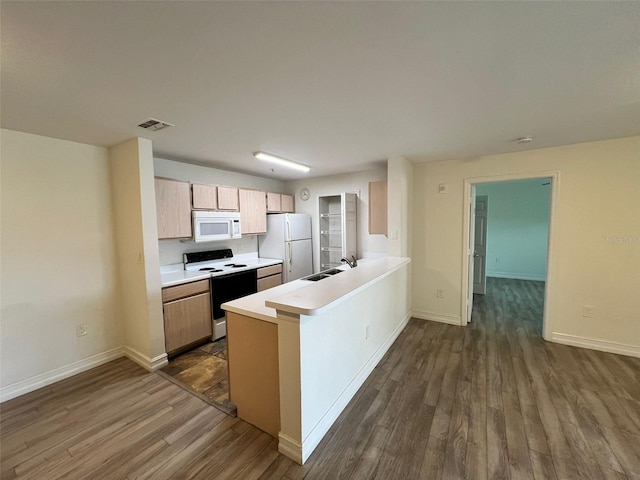 kitchen featuring light brown cabinets, sink, dark wood-type flooring, kitchen peninsula, and white appliances